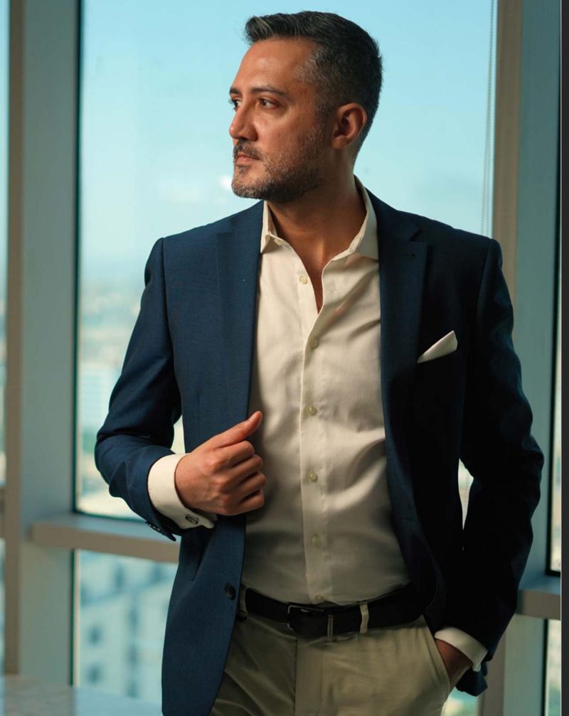 Zo Alam, entrepreneur and advisor in Dubai, in a navy blazer by a high-rise window